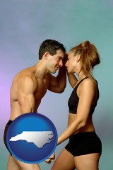 north-carolina map icon and a couple wearing black swimsuits